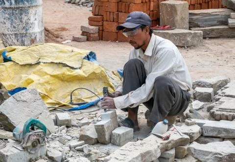 Man Shaping Stone With a Chisel and Hammer Stock Photos