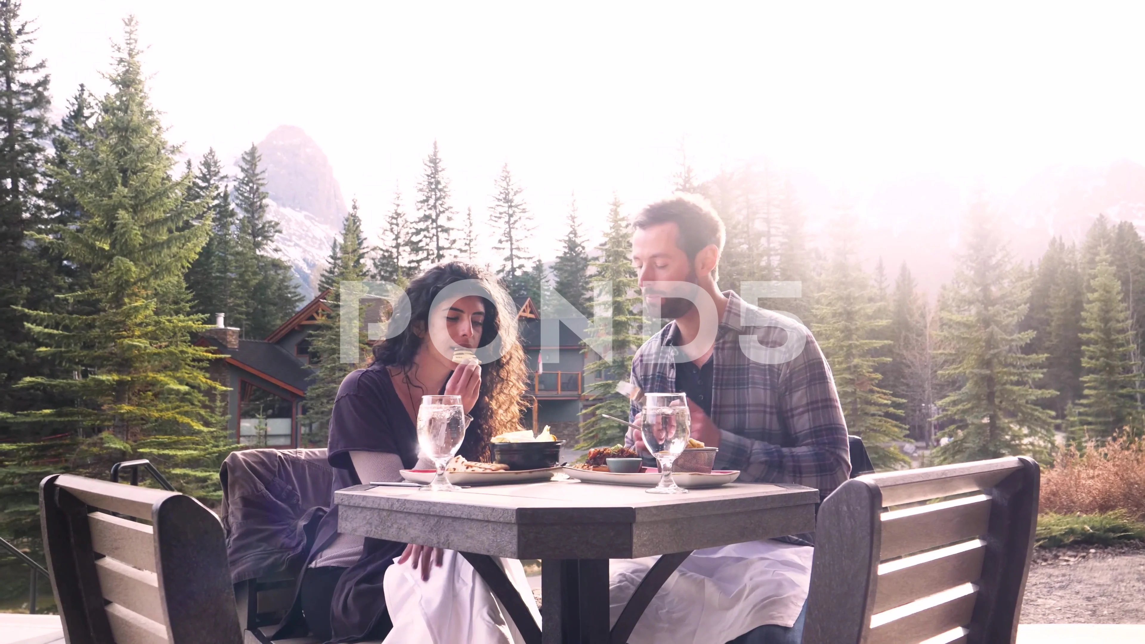 Man sharing food with wife on restaurant patio