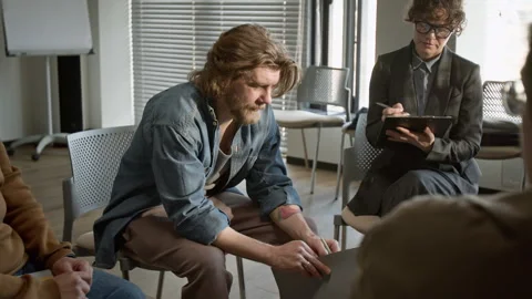 Man Sharing Problems during Group Therapy Session with Therapist Stock Footage 337239133