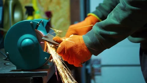 Man sharpening an ax blade on a grinder Stock Footage 193744597