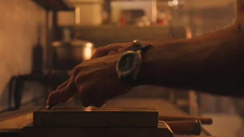 Man sharpening blade on wet stone in workshop Stock Footage 275632144