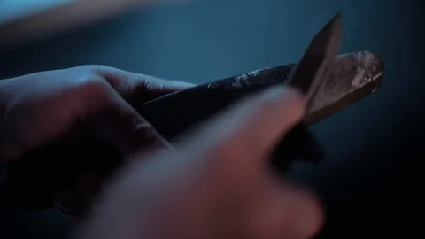 A man is sharpening a knife on a grindstone close-up. Video stock 123459771