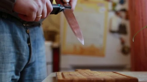 Man sharpening the knife in the kitchen Stock Footage 72961743