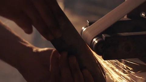 Man sharpening knife with sparks. Work on a sharpening machine. Stock Footage 134794488