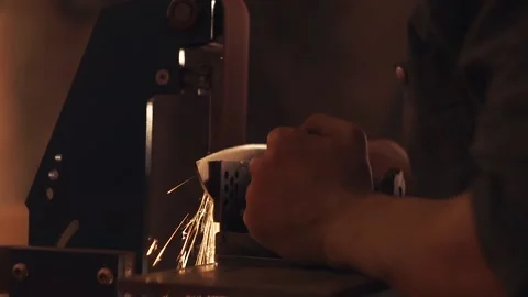 Man sharpening knife with sparks. Work on a sharpening machine. Stock Footage 134795852