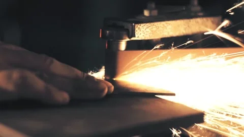Man sharpening knife with sparks. Work on a sharpening machine Stock Footage 135073323