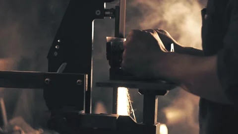 Man sharpening knife with sparks. Work on a sharpening machine Stock Footage 135080875