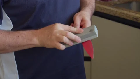 Man sharpening a knife with a stone Stock Footage 130265321
