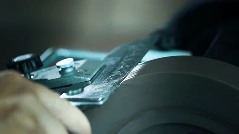 Man sharpening knives on a grinder. Close up hand Stock Footage 142156973