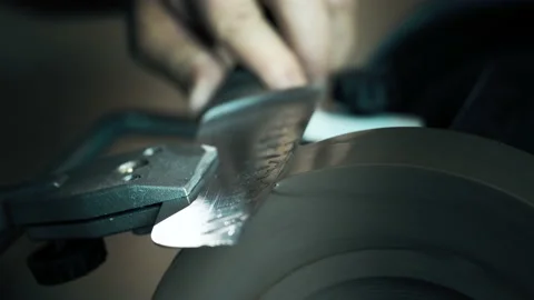 Man sharpening knives on a grinder. Macro Stock Footage 142156594