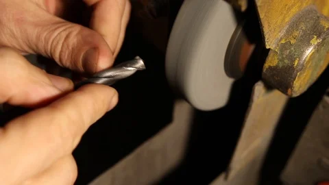 Man sharpening metal drill on a grinding wheel in the industrial factory. Stock Footage 125306250