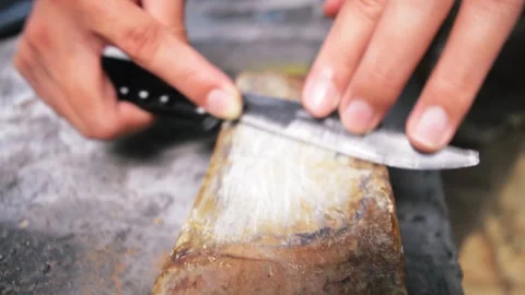 Man sharpening old butterfly knife on whetstone Stock Footage 276409557