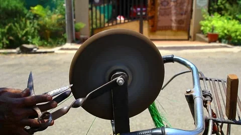A man sharpening a scissor on a rotating whetstone 60 FPS FHD Stock Footage 130793492