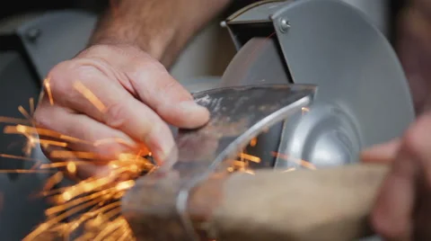 The man sharpens ax on a special machine. Stock Footage 67578116