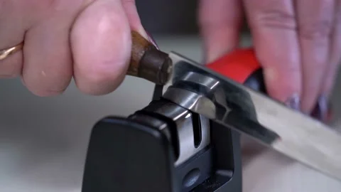A man sharpens a knife with a whetstone close-up. Chef hands sharpening knife in Stock Footage 151465942