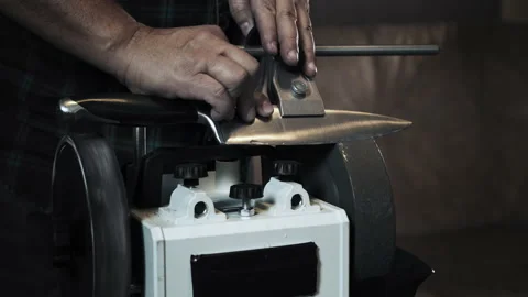 Man sharpens knives on a grinder. Close up hand Stock Footage 142154433