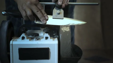 Man sharpens knives on a grinder. Close up hand Stock Footage 142154804