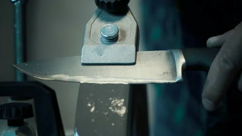 Man sharpens knives on a grinder. Close up hand Stock Footage 142156038