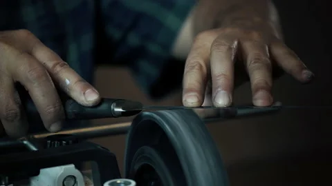 Man sharpens knives on a grinder. Close up hand Stock Footage 142157434