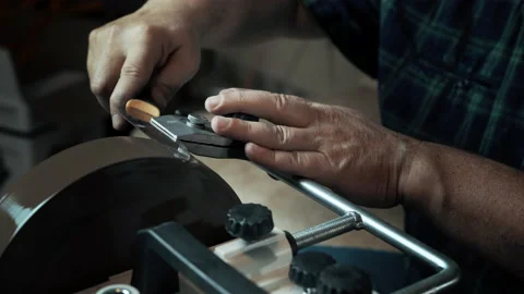Man sharpens knives on a grinder. Close up hand Stock Footage 143672333
