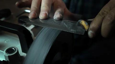 Man sharpens knives on a grinder. Close up hand Stock Footage 143672731