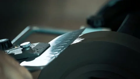 Man sharpens knives on a grinder. Macro shoot Stock Footage 142156828