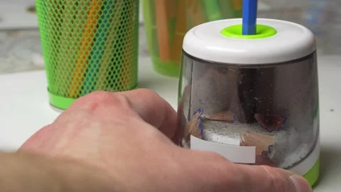 Man sharpens a pencil with an electric sharpener. Stock Footage 165506991