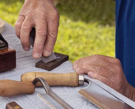 Man Sharpens Plane Blade on Oiled Whetstone Stock Photos
