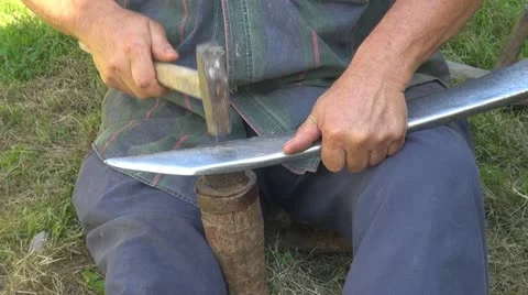 Man sharpens a scythe Stock Footage 10841764