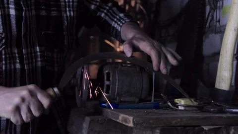 A man sharpens a sickle on a grinder sharpener close-up Stock-Footage 135654913