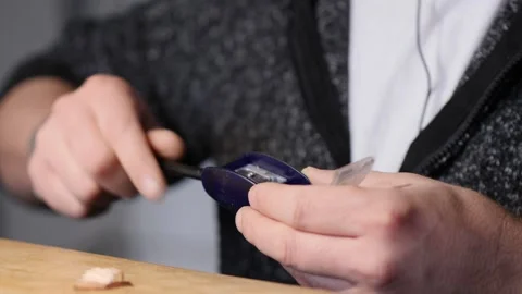 A man sharpens a simple pencil with a manual pencil sharpener. woodworking Stock Footage 147869846