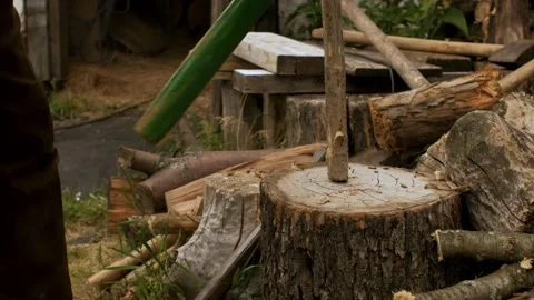 A man sharpens a stake and cuts chop wood for the garden and stove Video stock 138357887