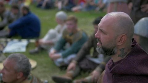 Man with a shaved head talking about something with another man Stock Footage 82409515