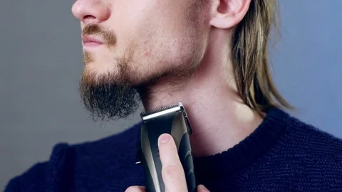 Man shaves beard with electric razor Stock Footage 111122510