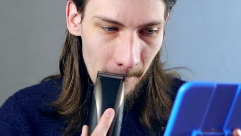 Man shaves beard with electric razor Stock Footage 115772325