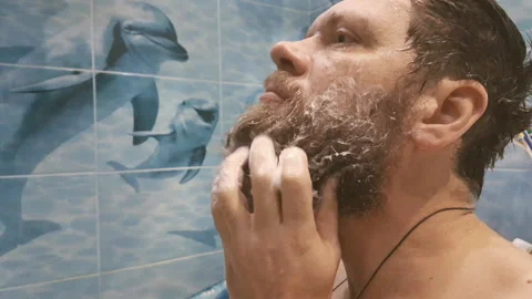 Man shaves beard in front of mirror Video stock 103571480