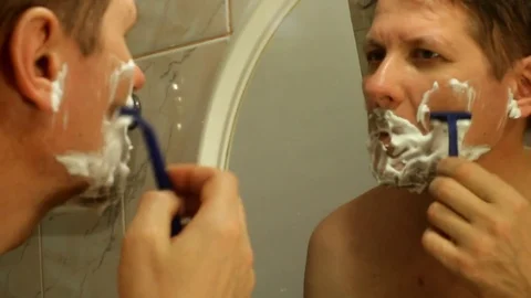 A man shaves a bristle with a blue disposable razor Video stock 82467282