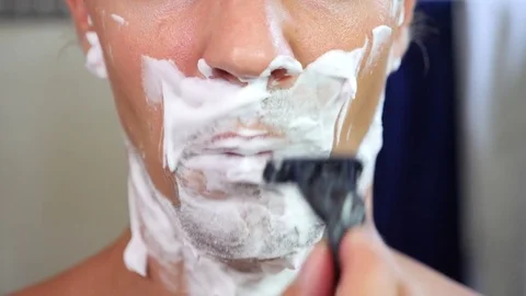 Man shaves his face. handsome man shaving in the bathroom. 4k, slow motion Stock Footage
