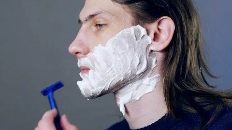 A man shaves with a razor Stock Footage 104335598