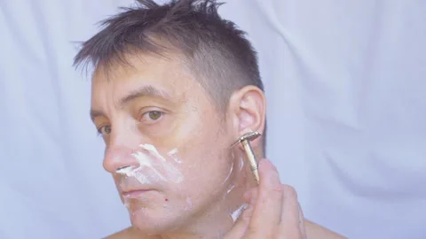 A man shaves with a razor. 库存影片 338399746