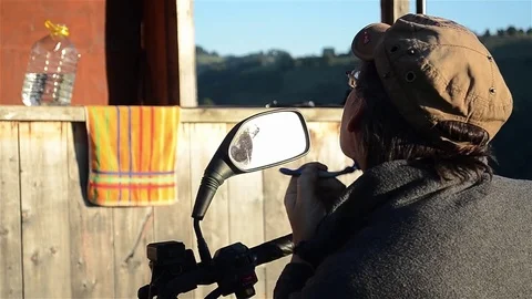 Man shaves using the mirror of a motorcycle Stock Footage 72266623