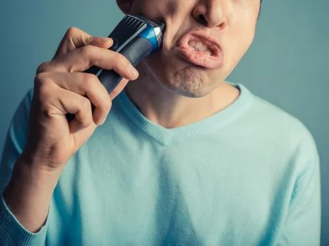 Man is shaving and pulling faces Photos