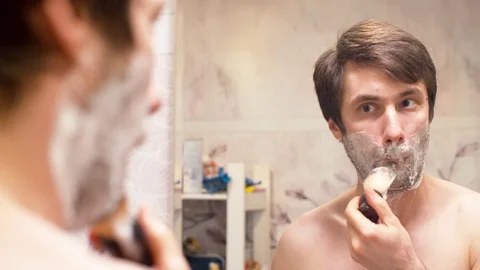 Man shaving in the bathroom Stock Footage 128916394
