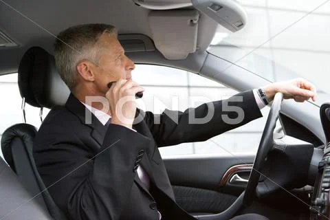 Man Shaving With Electric Razor In Car