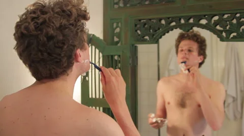 Man shaving in front of mirror Stock Footage 40843668