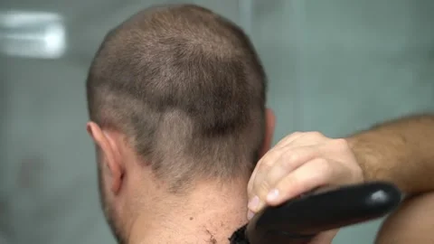 Man shaving head with electric clipper close up haircut Stock Footage 330997578