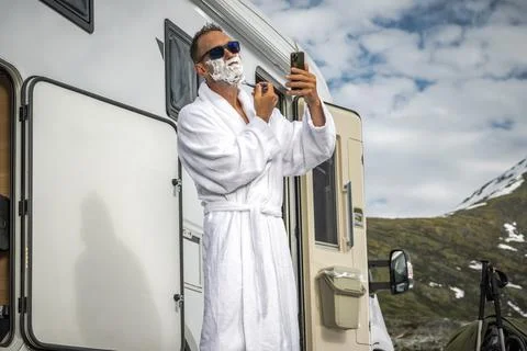 Man Shaving His Face in Front of His Camper Van Foto stock