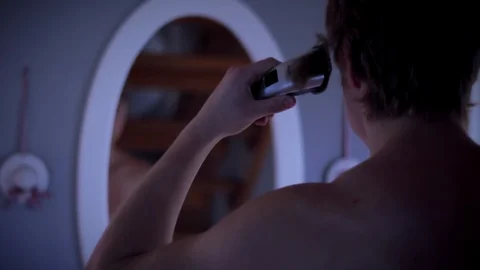 Man shaving his head, in front of a mirror Stock Footage 85491242