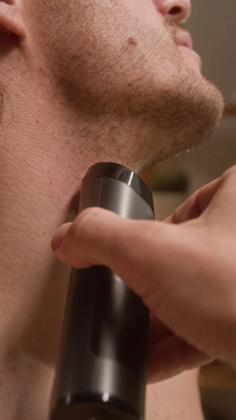 Man Shaving Neck Beard with Electric Trimmer for Grooming Stock Footage 342741352