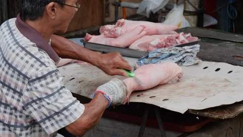 Man shaving pig legs with sharp knife in slow motion, Kuala Lumpur, Malaysia Stock Footage 146549045